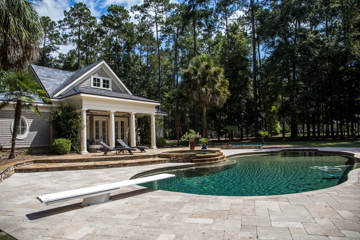 Custom pool House behind a landscaped estate with a large swimming pool and hot tub custom pool