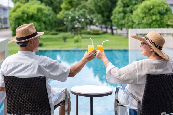 Drinks at the Pool Happy senior couple drinks by their pool after moving into their new home.