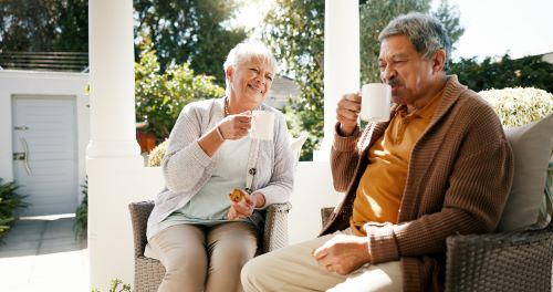 An elderly couple enjoys coffee on the private porch attached to their mother-in-law suite or casita. 