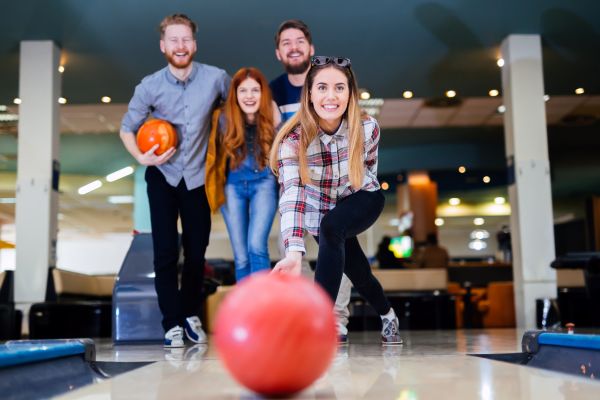 A group of four friends go bowling. 